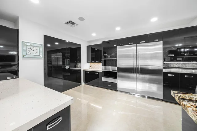 a living room with stainless steel appliances kitchen island granite countertop furniture a fireplace and a flat screen tv