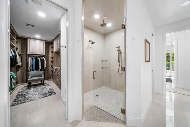 a view of walk in closet with clothes and shoes