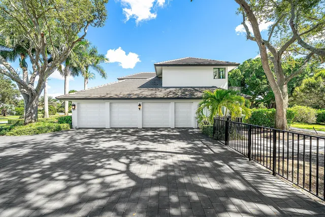 a front view of a house with a garden and tree