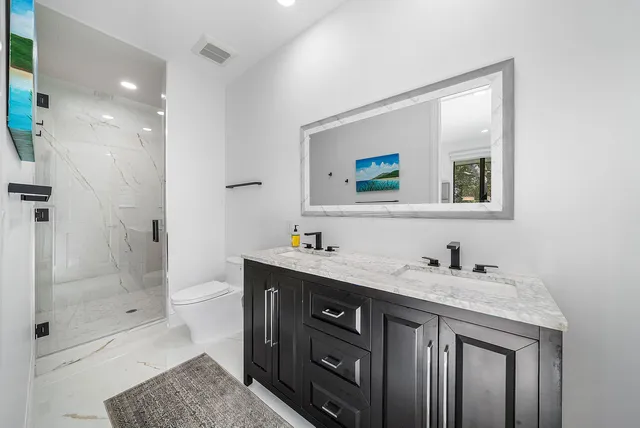 a view of grassy field with benches and trees all around