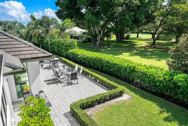an aerial view of residential house with outdoor space and trees all around