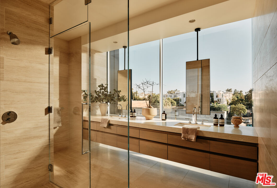 8899 Beverly Boulevard, Unit 4D Los Angeles, CA 90048 - Photo 13 of 28 a bathroom with a double vanity sink a mirror and a shower