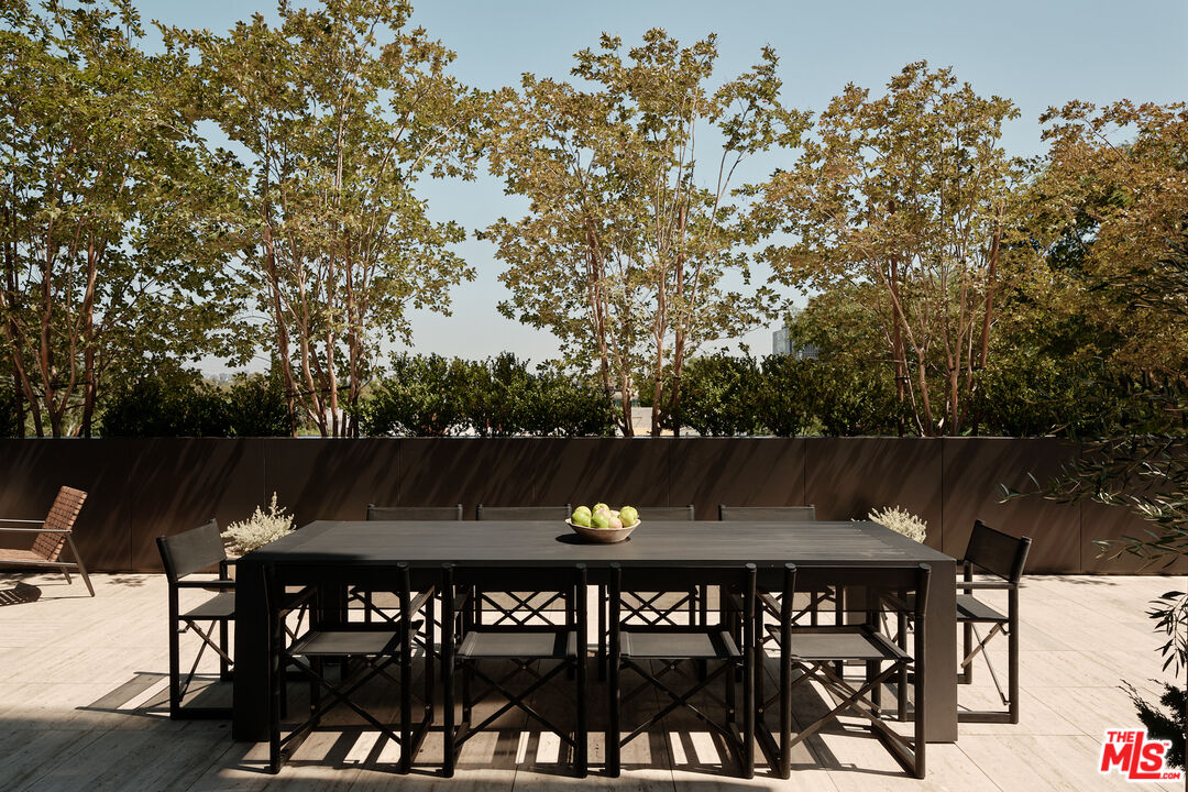 8899 Beverly Boulevard, Unit 4D Los Angeles, CA 90048 - Photo 16 of 28 a view of a roof deck with table and chairs and wooden floor