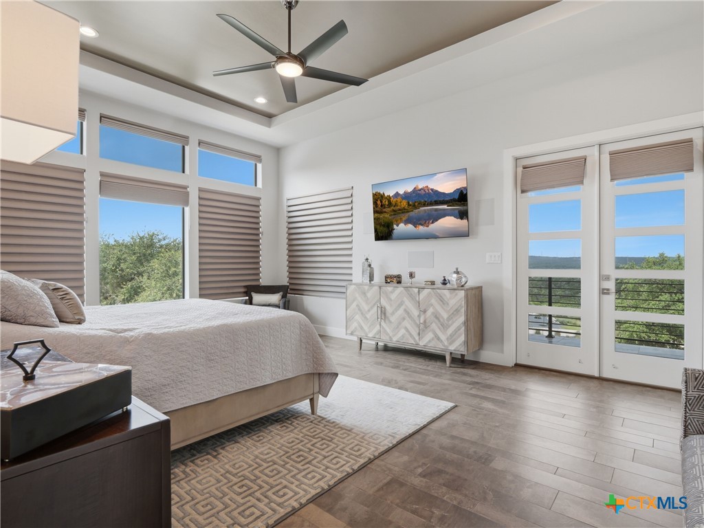 5913 Verden Ridge New Braunfels, TX 78132 - Photo 13 of 48 a bedroom with a large bed and a flat tv screen
