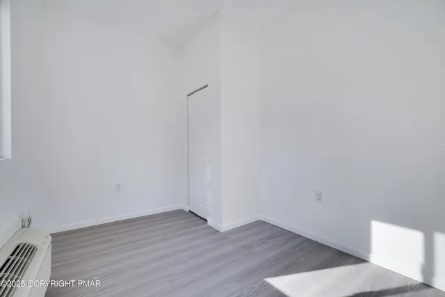 a view of an empty room with wooden floor