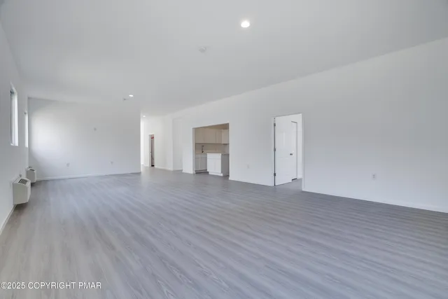 a view of an empty room and wooden floor