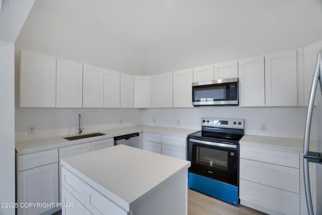 a kitchen with a sink appliances and cabinets