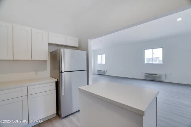 a kitchen with a refrigerator sink and cabinets