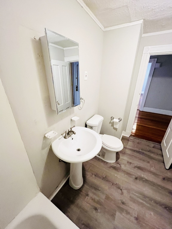 69 Adams Street, Unit 2 Boston, MA 02122 - Photo 3 of 5 a bathroom with a sink a toilet and mirror