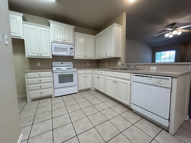 a kitchen with cabinets and appliances