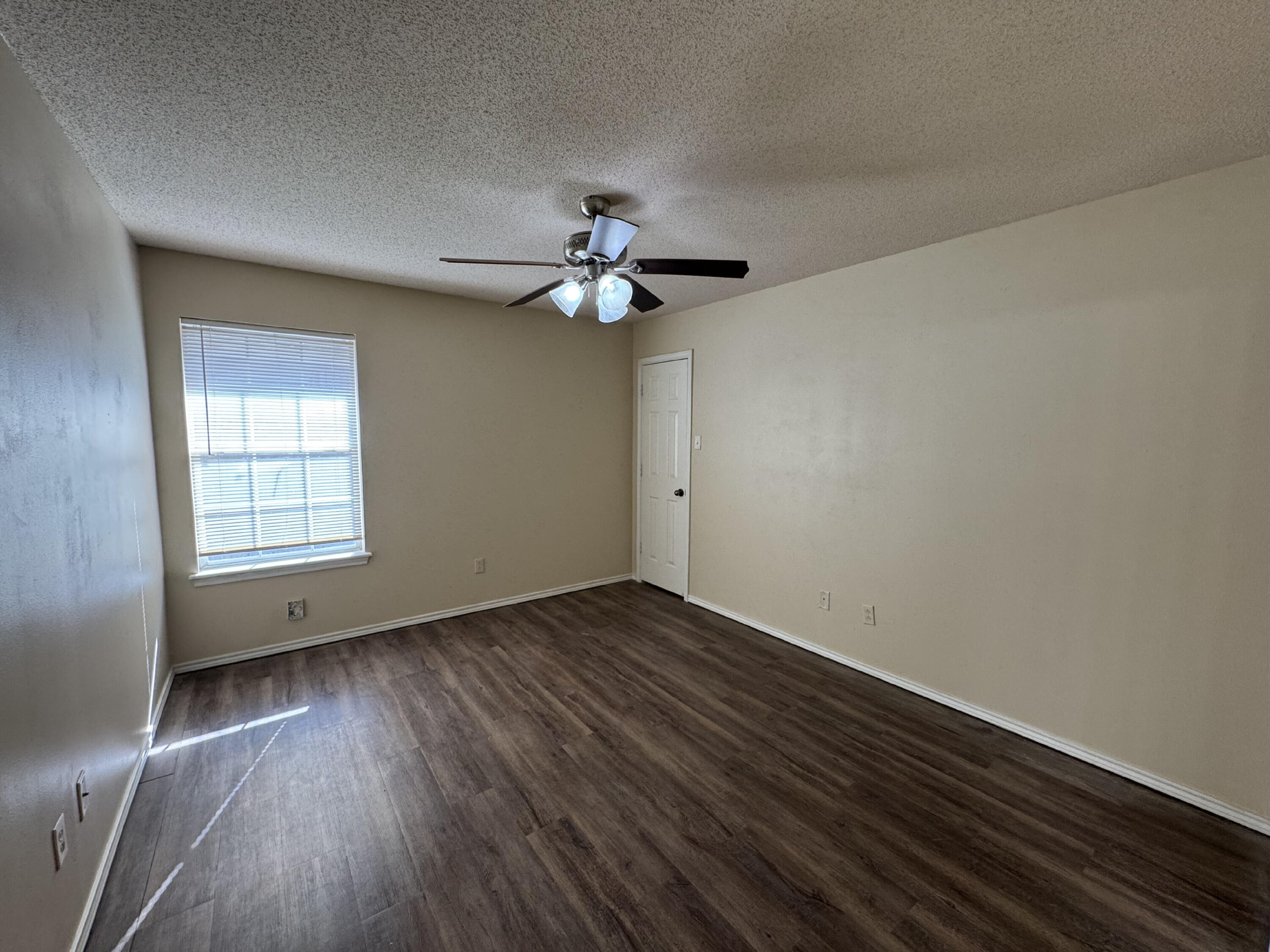 511 North Clinton Avenue, Unit A Lubbock, TX 79416 - Photo 9 of 15 wooden floor in an empty room with a window