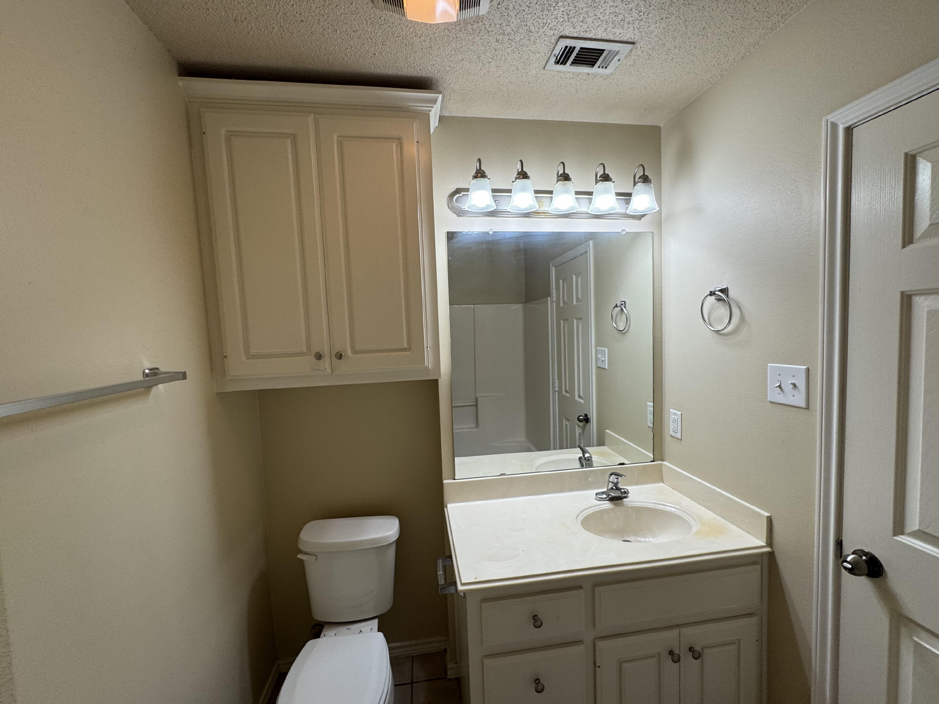 511 North Clinton Avenue, Unit A Lubbock, TX 79416 - Photo 10 of 15 a bathroom with a toilet sink and mirror