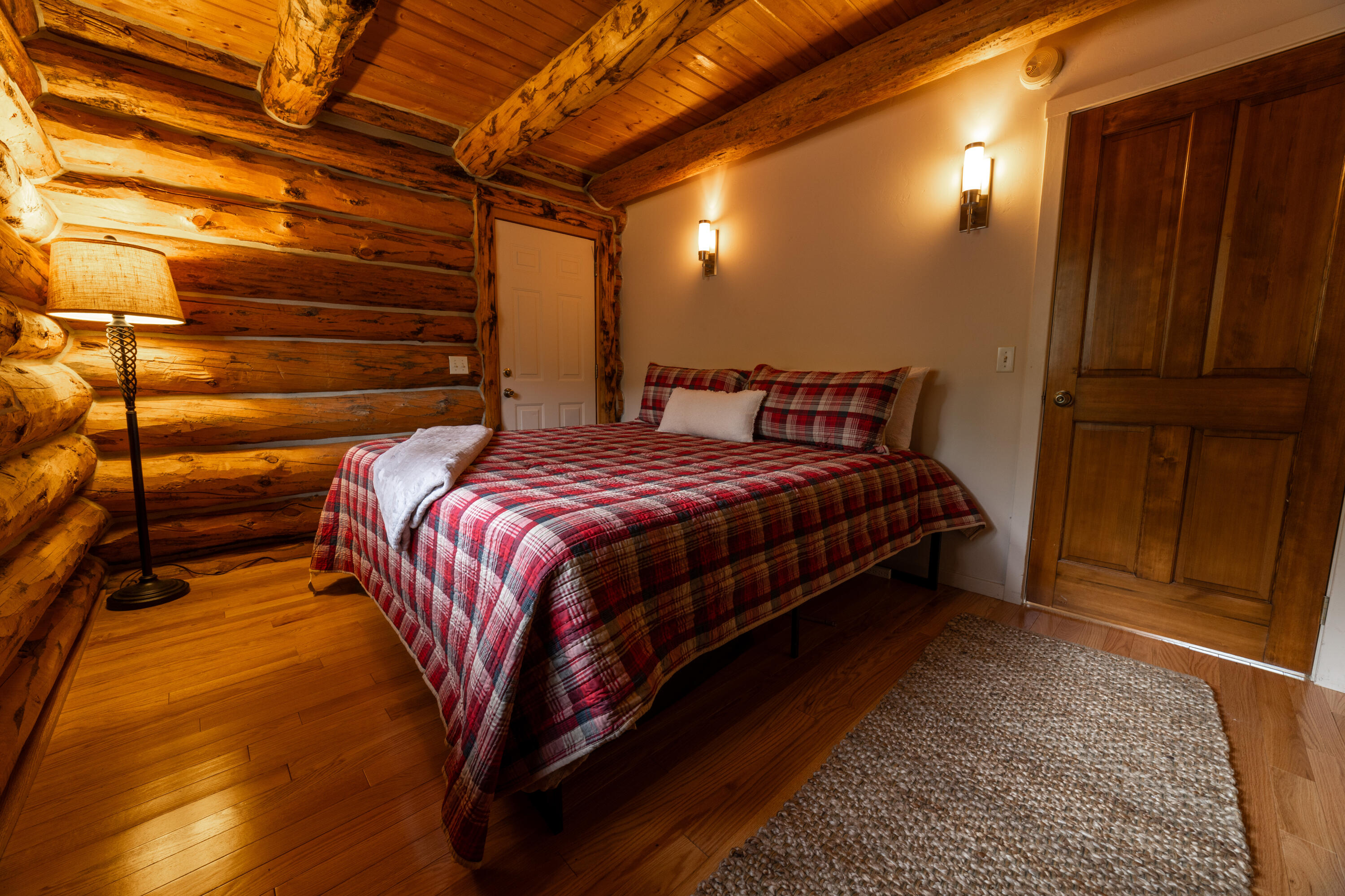 2001 County Road Placerville, CO 81430 - Photo 22 of 37 a bed sitting in a bedroom next to a wooden door