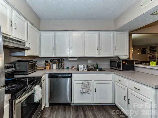 a kitchen with stainless steel appliances granite countertop a stove a sink and cabinets