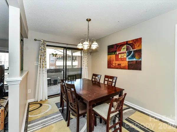 a dining room with furniture a rug and a chandelier