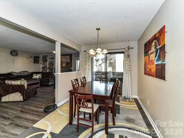 a dining room with furniture a chandelier and wooden floor
