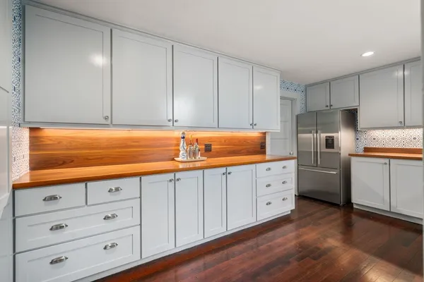 a kitchen with granite countertop white cabinets and white stainless steel appliances