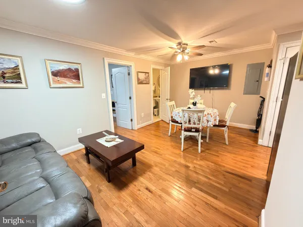 a living room with furniture a flat screen tv and a dining table