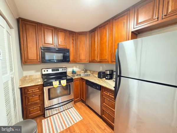 a kitchen with granite countertop a refrigerator stove top oven and sink