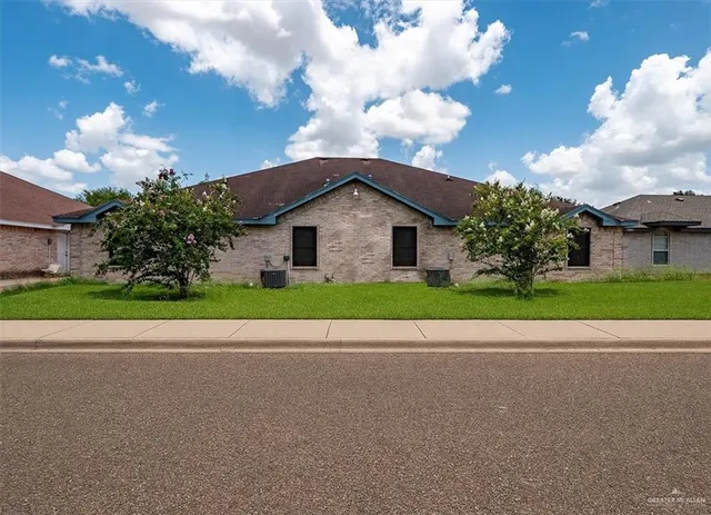 a white house with a big yard and a large parking space