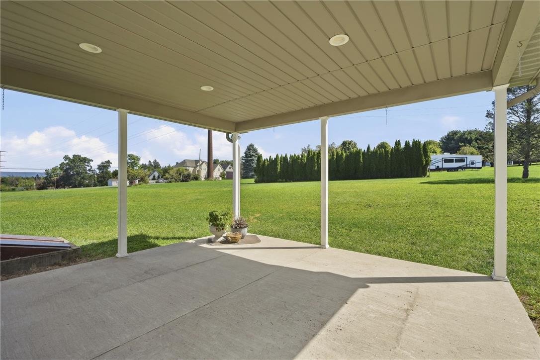 590 Fehr Road Nazareth, PA 18064 - Photo 60 of 79 A sheltered concrete patio looks out over a massive, green lawn bordered by mature trees.