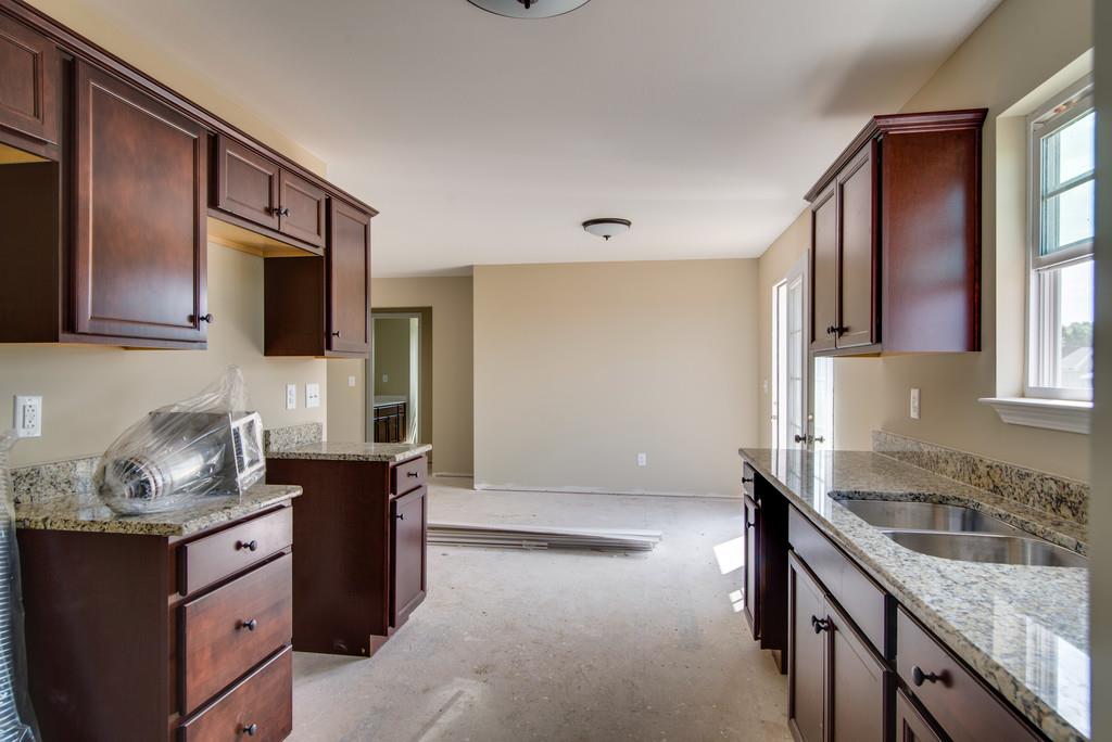 590 Murrell Road Dickson, TN 37055 - Photo 6 of 25 a kitchen with granite countertop a sink stove and cabinets