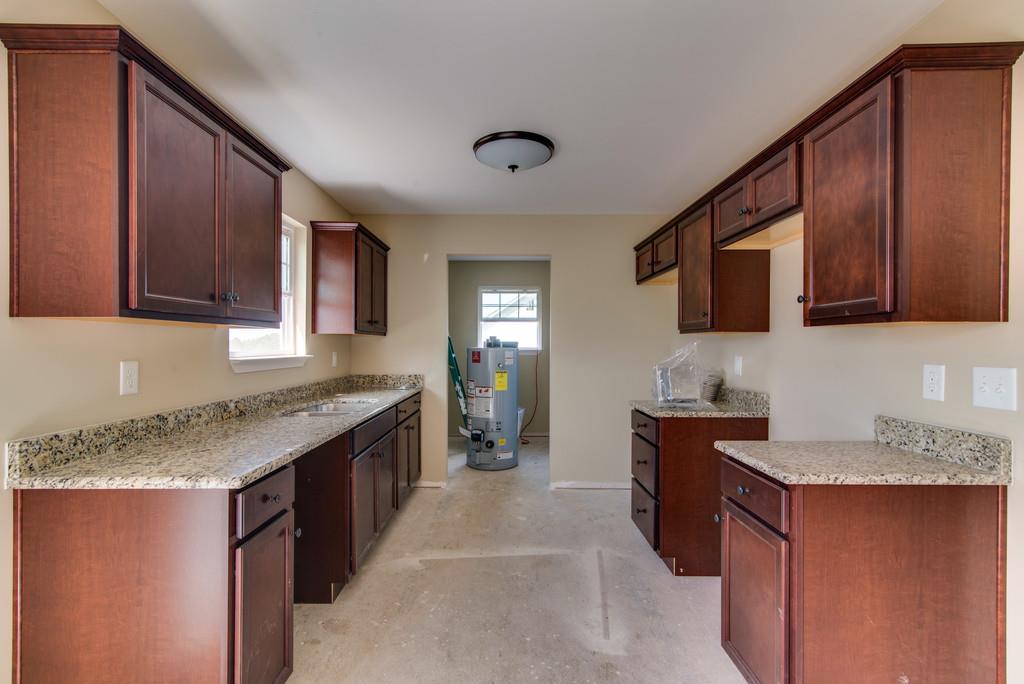 590 Murrell Road Dickson, TN 37055 - Photo 7 of 25 a kitchen with granite countertop a sink stove and cabinets