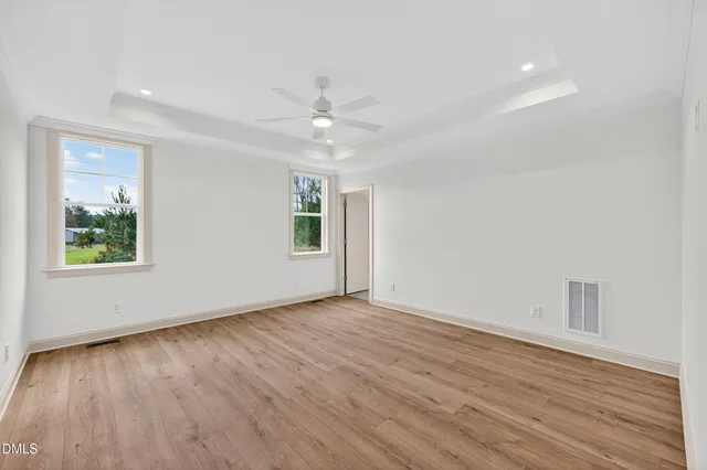 an empty room with a window and a ceiling fan