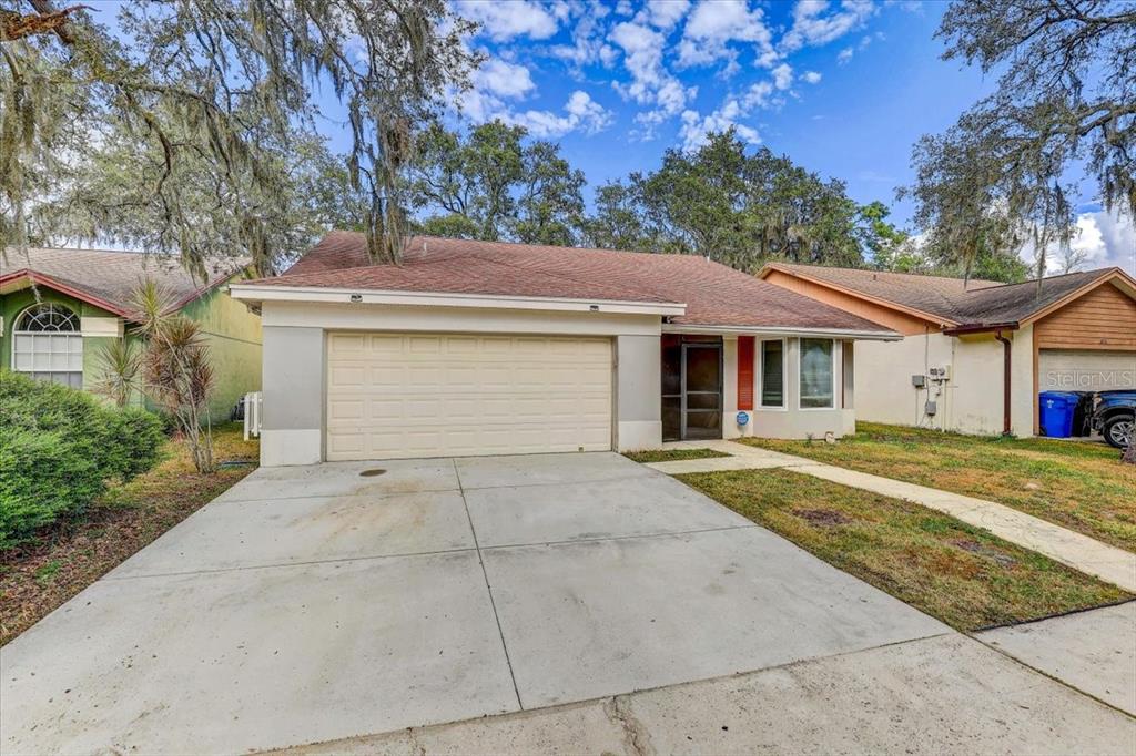 2524 Wrencrest Circle Valrico, FL 33596 - Photo 28 of 36 a front view of a house with a yard and garage