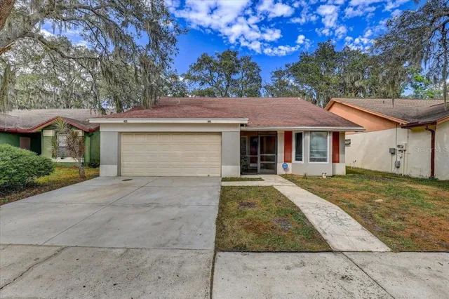 a view of a house with a yard and large tree