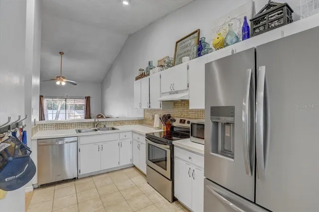 a kitchen with stainless steel appliances kitchen island granite countertop a sink and cabinets