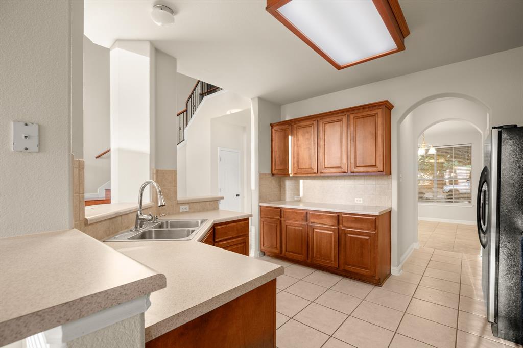 10105 Wind Cave Trail Austin, TX 78747 - Photo 7 of 23 Kitchen featuring wood cabinetry, stone-finish countertops, and a double basin sink