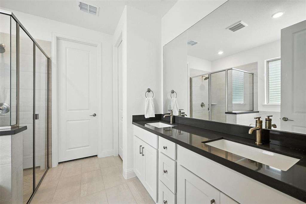447 Holly Road Little Elm, TX 75068 - Photo 17 of 30 a large bathroom with a granite countertop double vanity sink and mirror