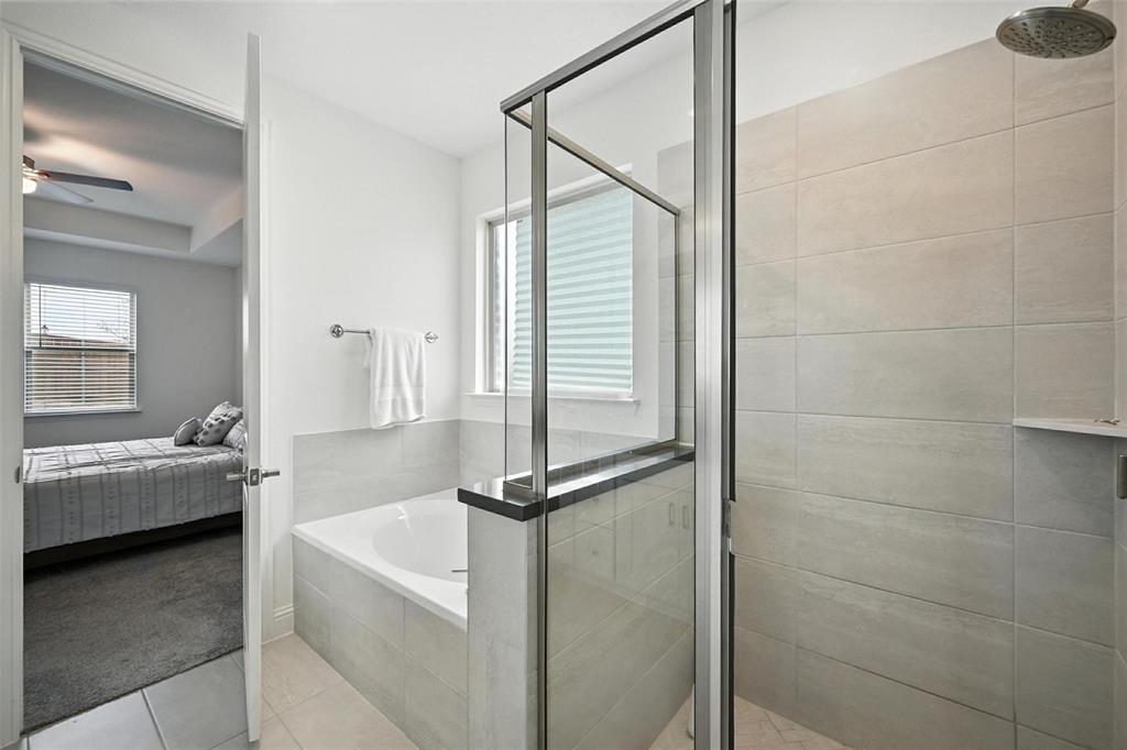 447 Holly Road Little Elm, TX 75068 - Photo 18 of 30 a bathroom with a tub sink and mirror