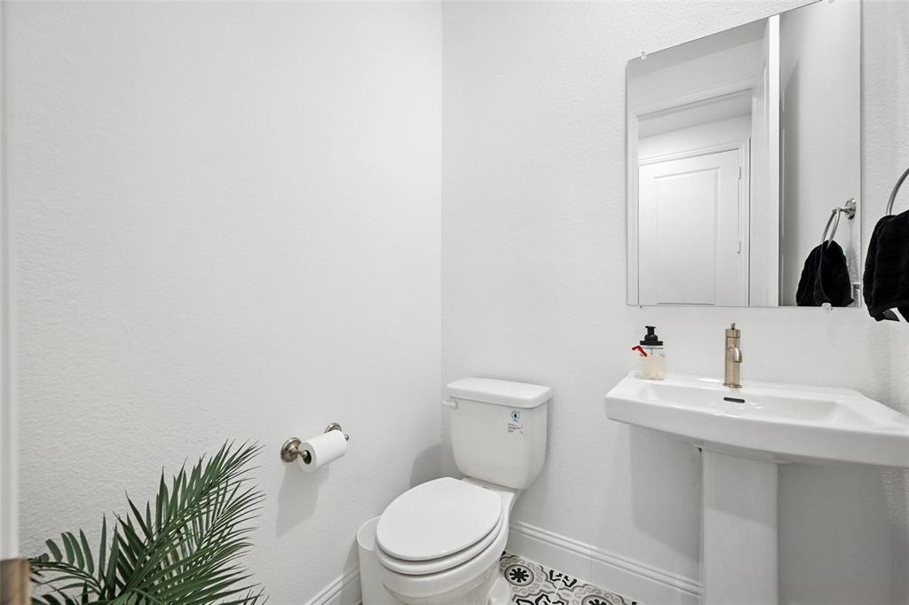 447 Holly Road Little Elm, TX 75068 - Photo 20 of 30 a bathroom with a toilet a sink and mirror