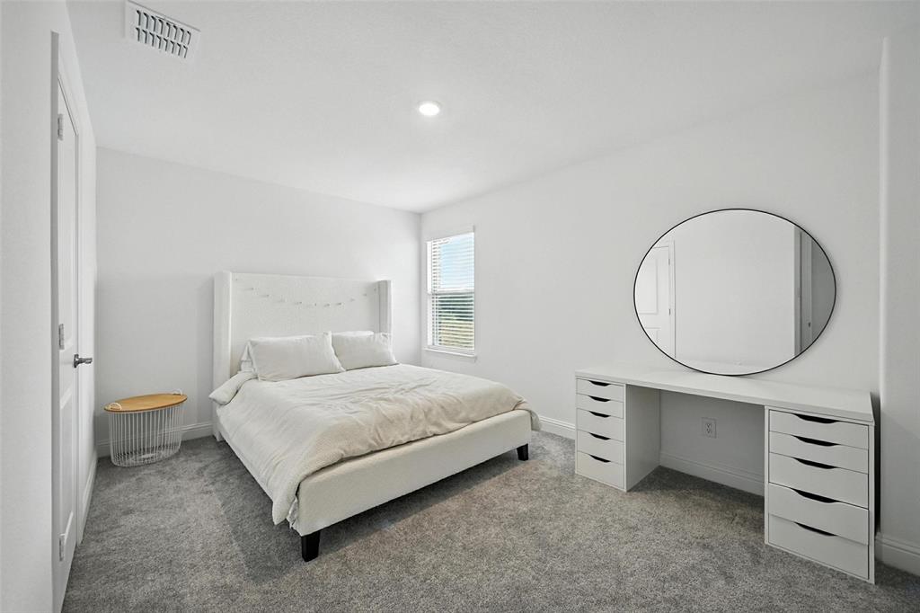 447 Holly Road Little Elm, TX 75068 - Photo 24 of 30 a bedroom with a bed a closet and a mirror