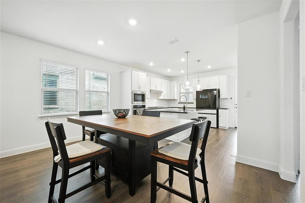 447 Holly Road Little Elm, TX 75068 - Photo 9 of 30 a view of a dining room with furniture and wooden floor