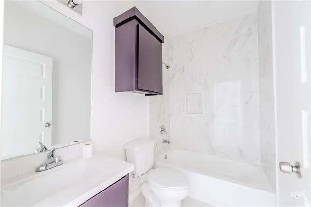 a bathroom with a bathtub shower sink vanity mirror and toilet