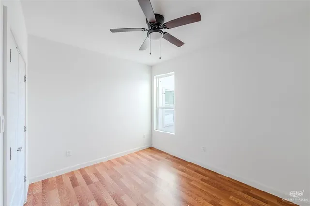 an empty room with a window and a fan