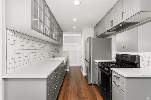 a kitchen with stainless steel appliances a refrigerator and a stove