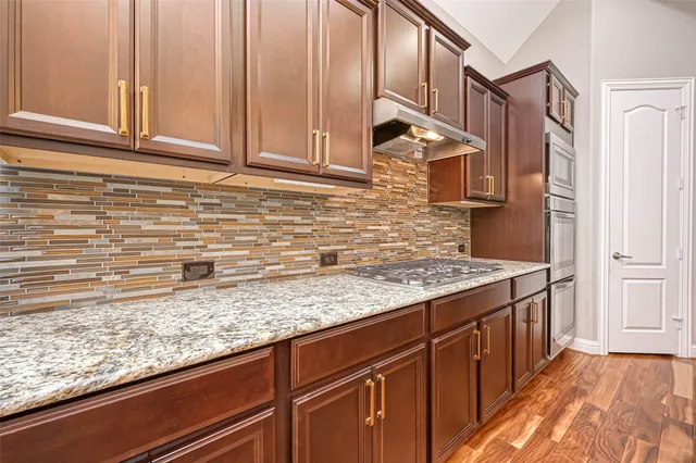 a kitchen with stainless steel appliances granite countertop a sink and cabinets