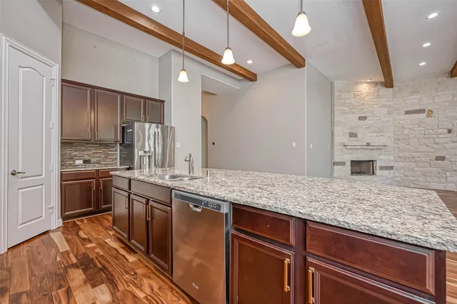 a kitchen with stainless steel appliances granite countertop a sink stove and refrigerator