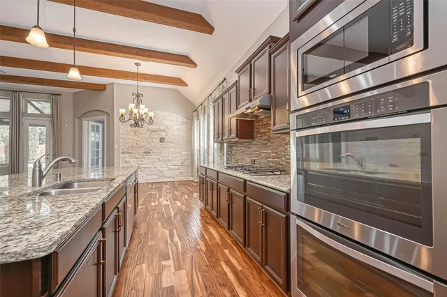 a kitchen with stainless steel appliances granite countertop a stove and cabinets