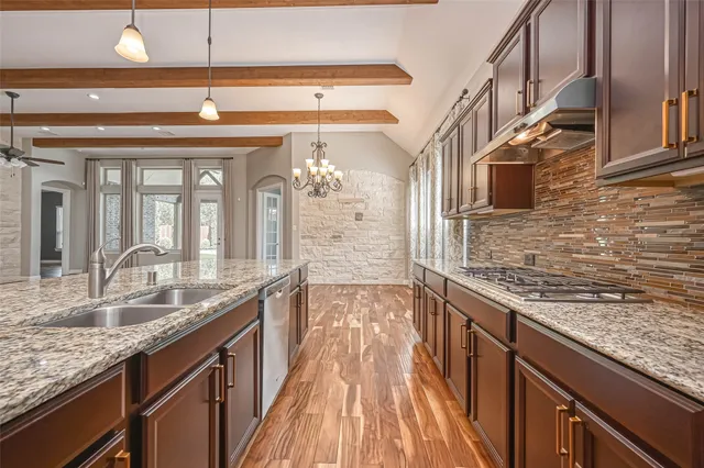 a kitchen with stainless steel appliances granite countertop a sink stove and cabinets