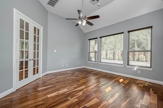 a view of an empty room with a window and wooden floor