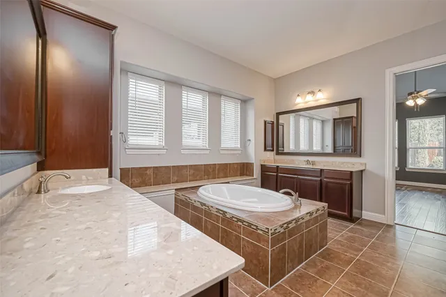a bathroom with a tub sink and mirror
