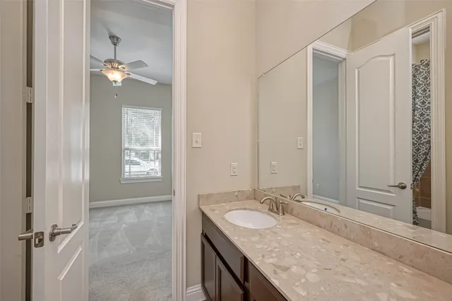 a bathroom with a granite countertop sink a light fixture and a window
