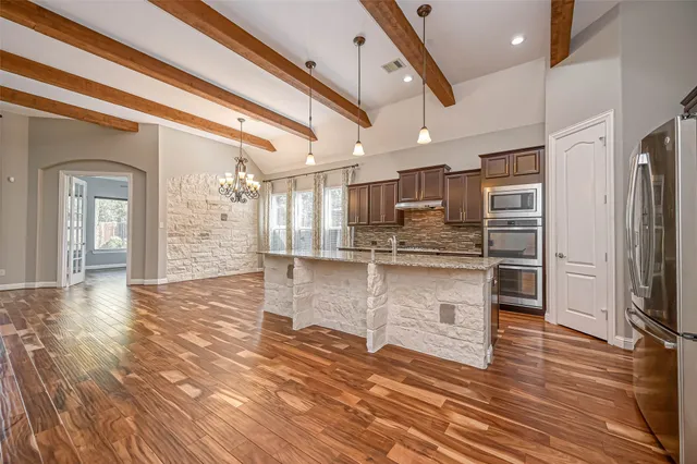 a kitchen with stainless steel appliances a refrigerator and a stove top oven