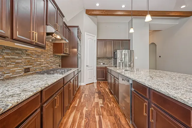 a kitchen with stainless steel appliances granite countertop a sink and stove