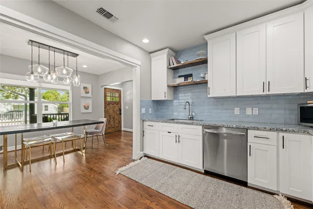 a large kitchen with stainless steel appliances granite countertop a stove and cabinets